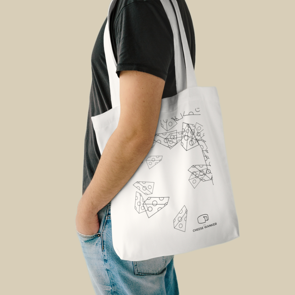 Hip male cheese lover carrying cheese line art market bag on his shoulder