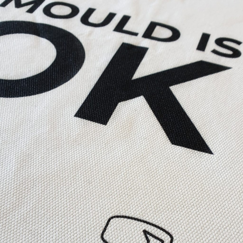 Close up of Mould is OK print on white market bag