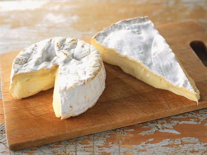 Camembert vs Brie soft cheeses on a wooden board