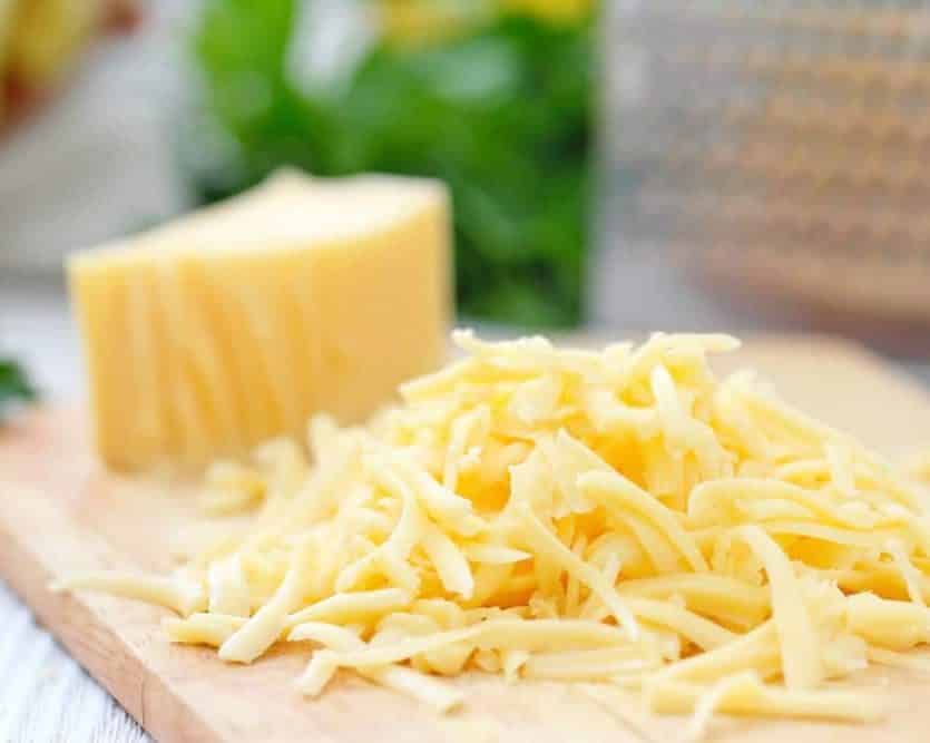 grated cheese next to a block of cheese