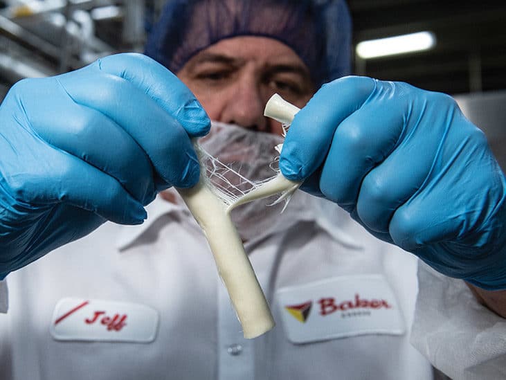 Cheesemaker pulling Baker String cheese apart