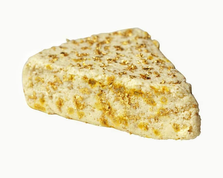 Flecks of edible gold sheet on white stilton cheese
