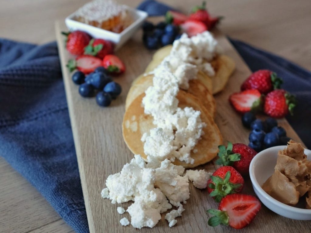 Fresh cheese ricotta on a cheese platter with pancakes