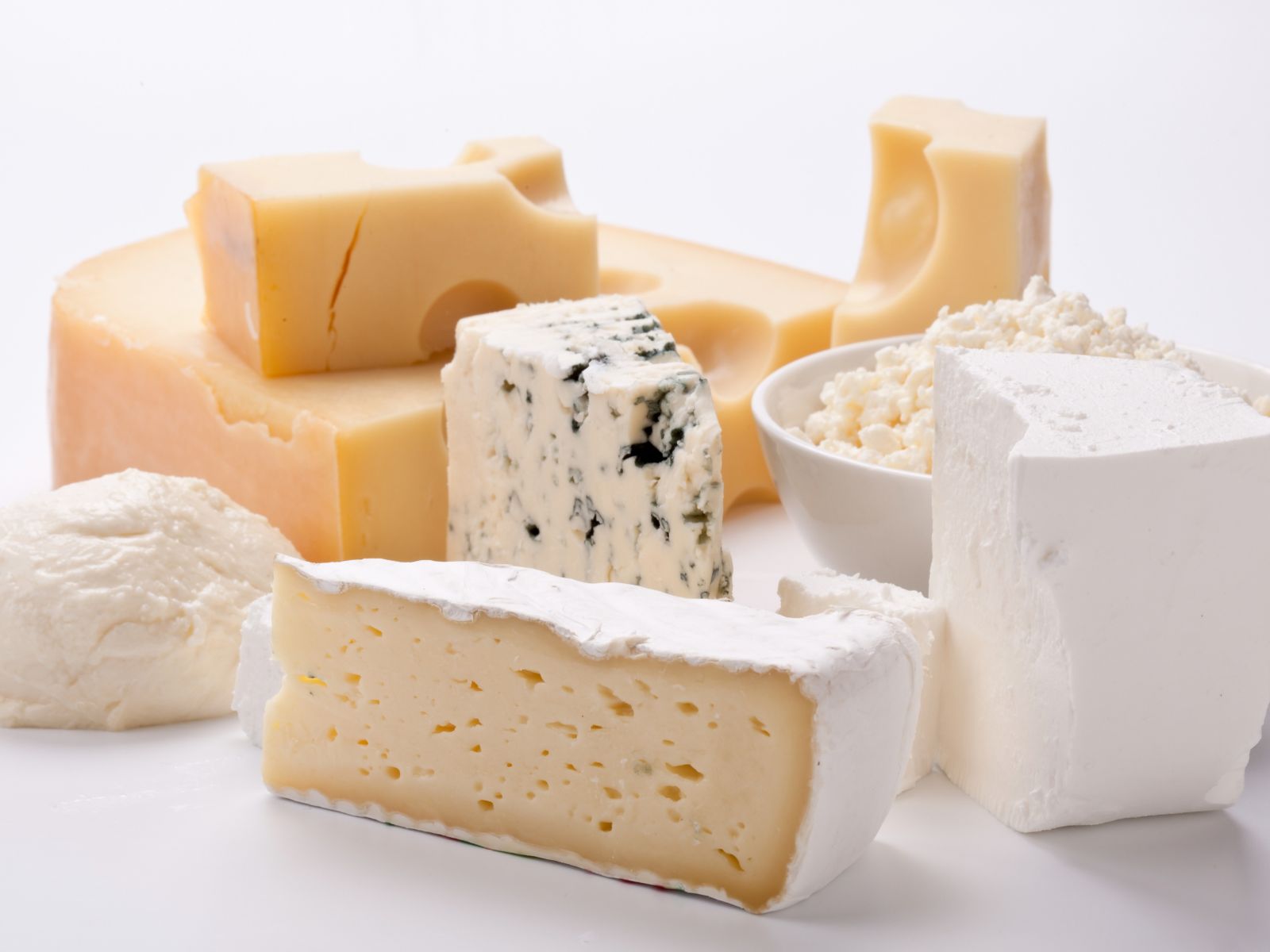 Many different types of cheese on a white surface