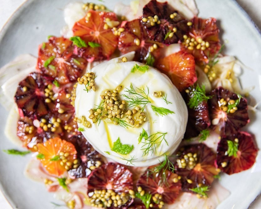 Fresh salad with burrata cheese, blood orange and fennel on a plate