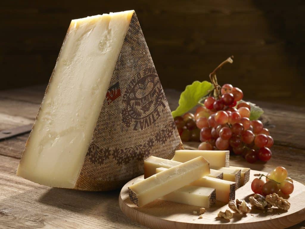 Swiss semi-hard cheese L'Etivaz on wooden table