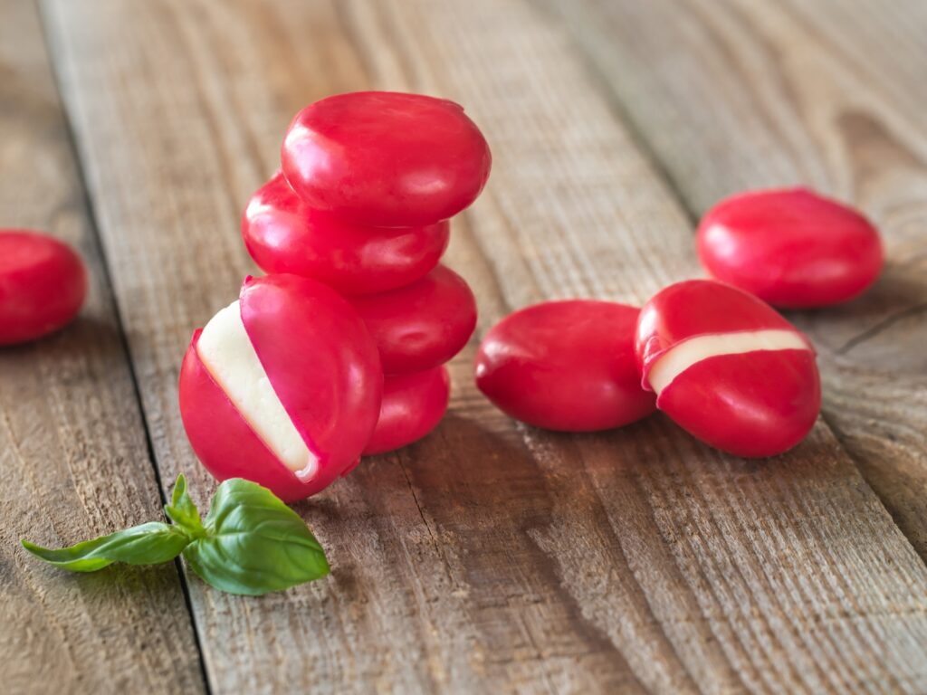Rounds of red Babybel cheese on a wooden table