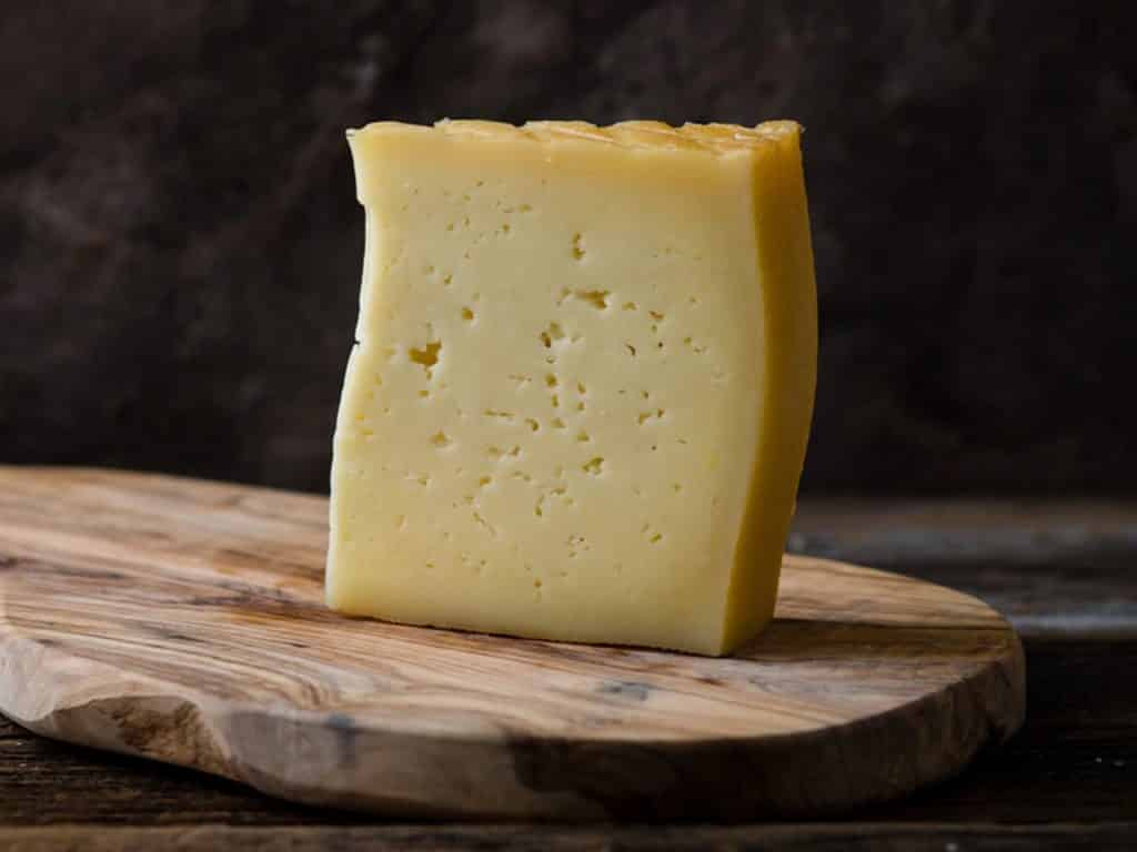Wedge of Spanish hard cheese Idiazabal with tiny holes
