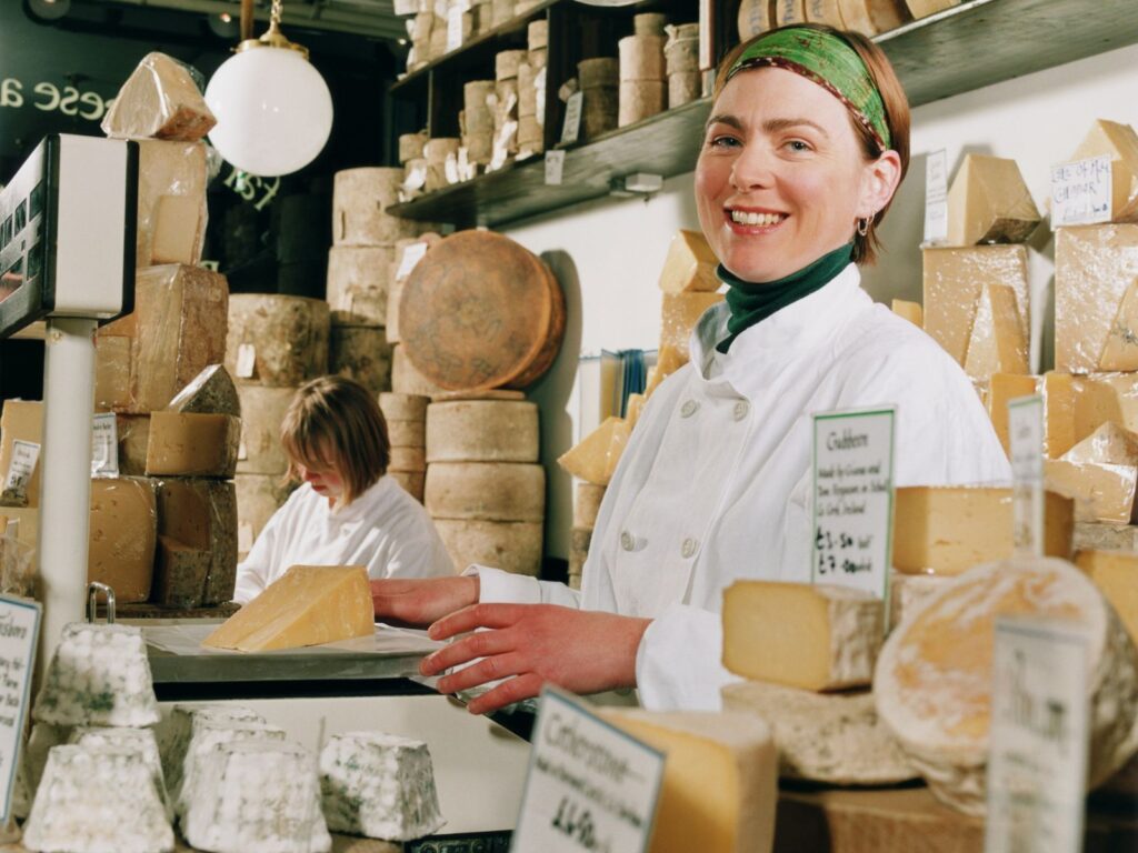 Female caucasian Cheese Monger selling artisanal cheese