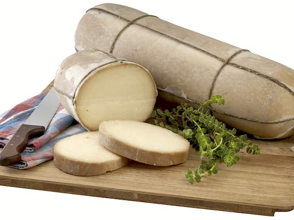 Log of Metsovone Greek PDO cheese on a chopping board