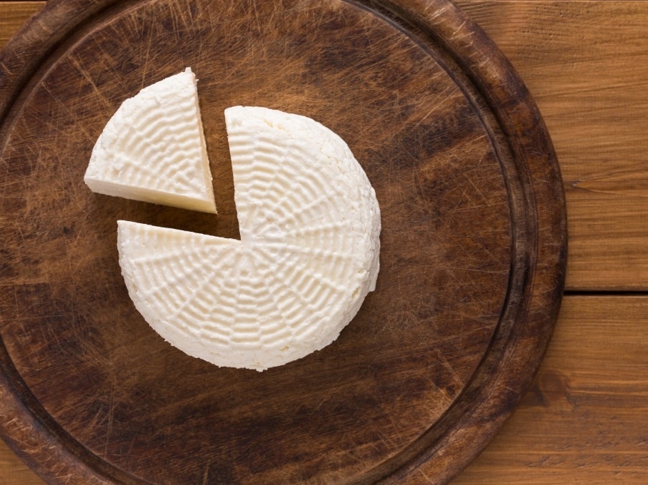 Flatlay of Kalathaki Limnou Greek PDO cheese on wooden board