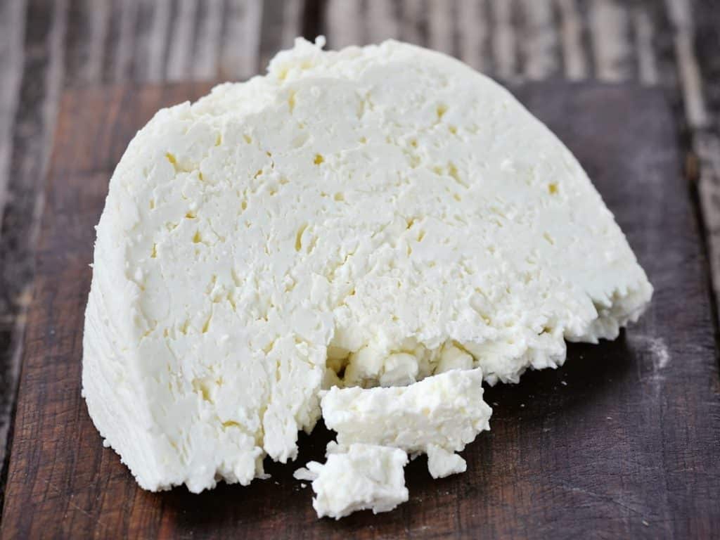 Crumbly white Kopanisti Greek PDO cheese on slate board