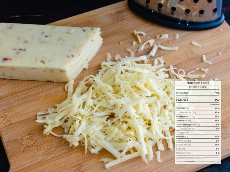 Block of Pepper Jack cheese grated on wooden board with nutrition facts overlaid