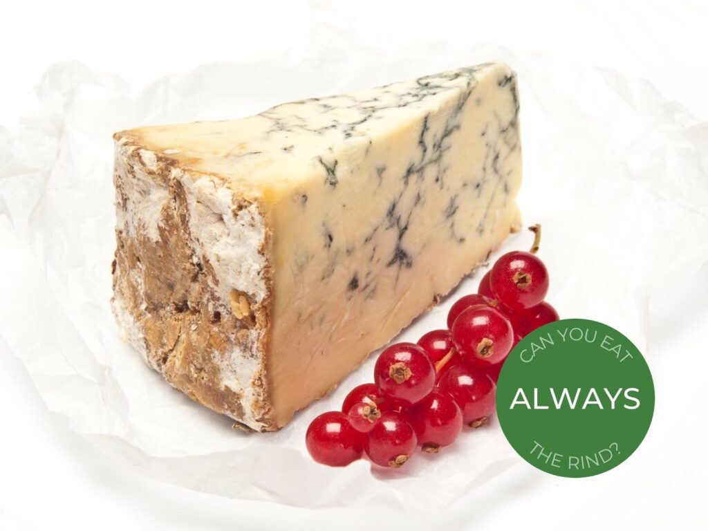 Wedge of Stilton blue cheese on paper with glacé cherries