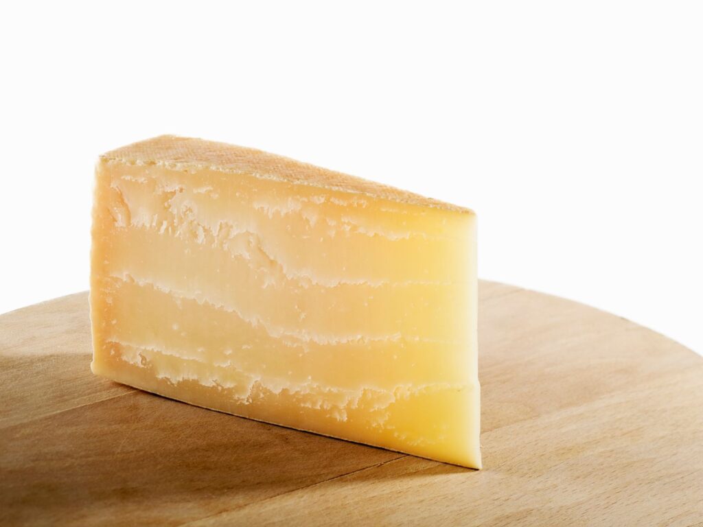 Slice of Piave hard cheese on cheese board