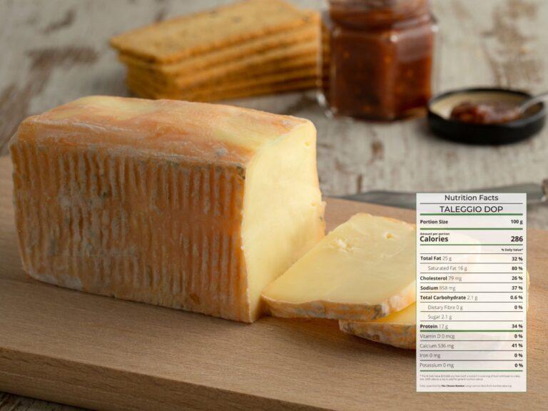 Brick of Taleggio soft cheese sliced on wooden board