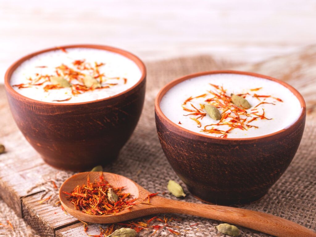 2 bowls of lassi topped with saffron and cardamon