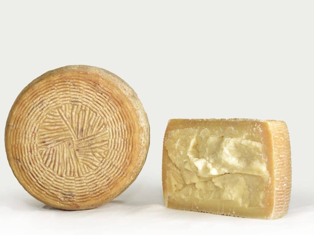 Pecorino Crotonese cheese cut in half against a light backdrop