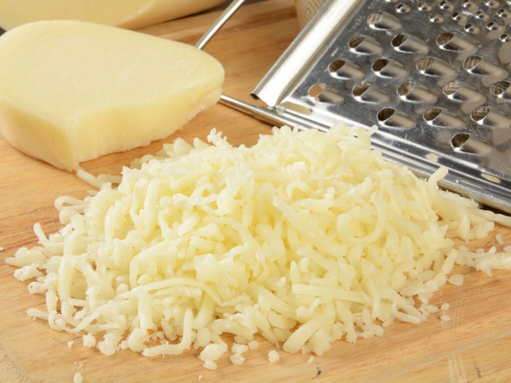 Low Moisture Mozzarella cheese grated on wooden board
