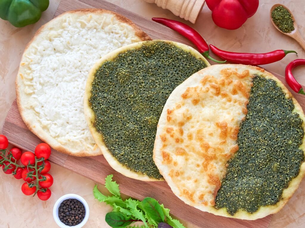 Three Syrian Manakeesh breads topped with white cheese and za'atar