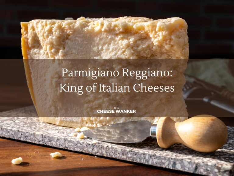 Chunk of hard Parmigiano Reggiano cheese on a marble board