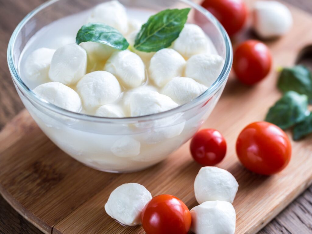 Bowl of small Bocconcini balls with cherry tomatoes and basil
