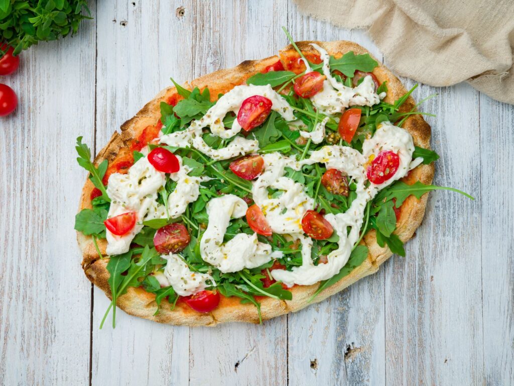 String of Straciatella fresh cheese served on flat bread with rocket and cherry tomatoes