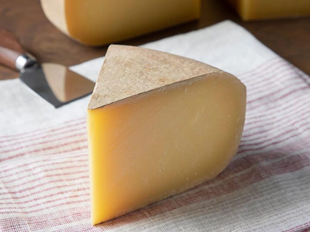Wedge of semi-hard cheese Pleasant Ridge Reserve with gorgeous natural rind
