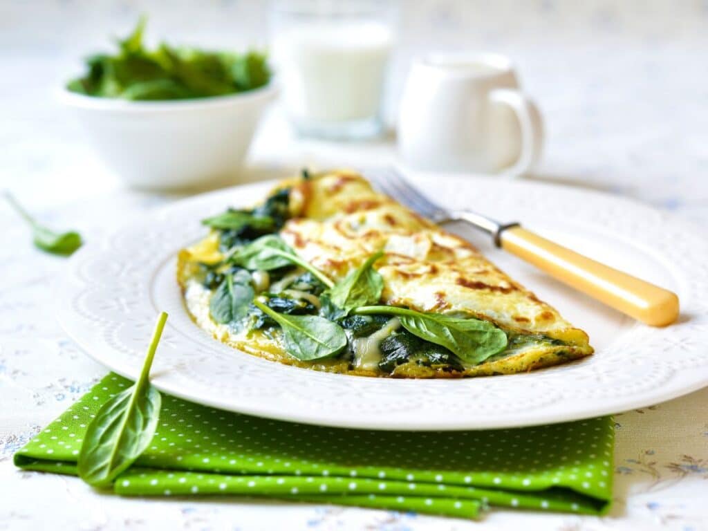 Gouda and Spinach Omelette on white plate next to green tea towel